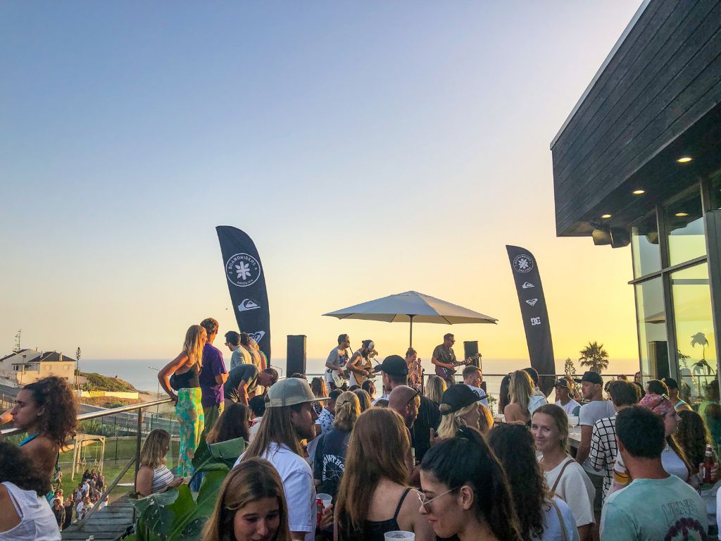 People dancing around a DJ at sunset at Boardriders Surf Shop