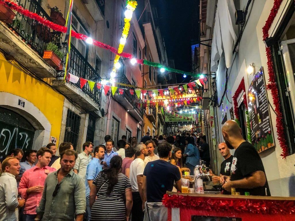 A busy street with ribbons and streamers for the Lisbon festas