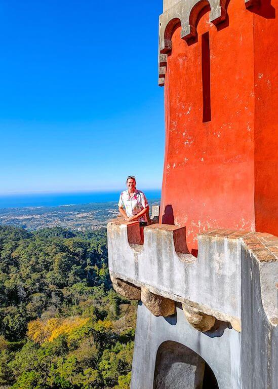 Nicola standing on a narrow path outside a red building at the Pena Palace
