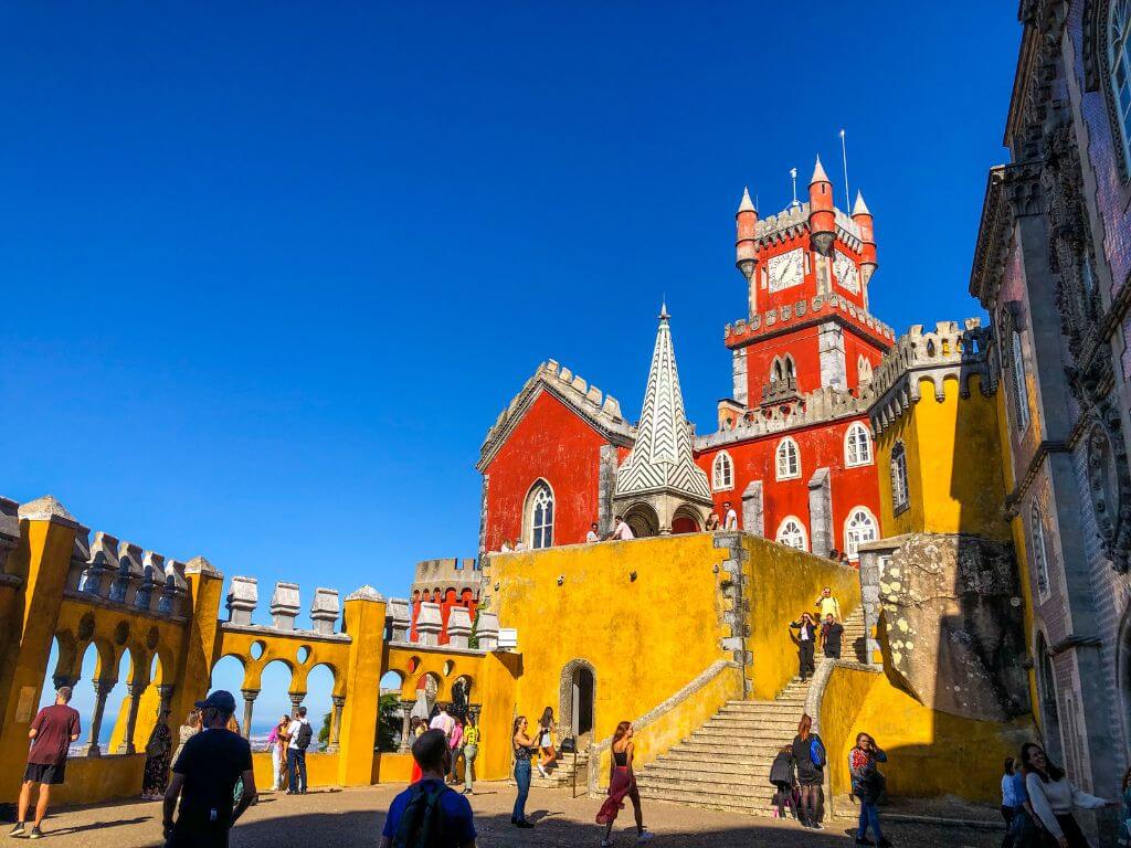The Hall of Arches at Pena Palace with a red clock tower in the background