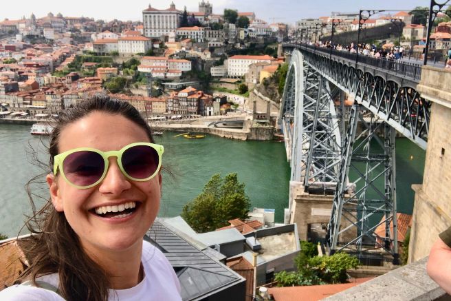 Nicola by the Porto Bridge Nicola wears lime green sunglasses and smiles in front of the Porto Bridge