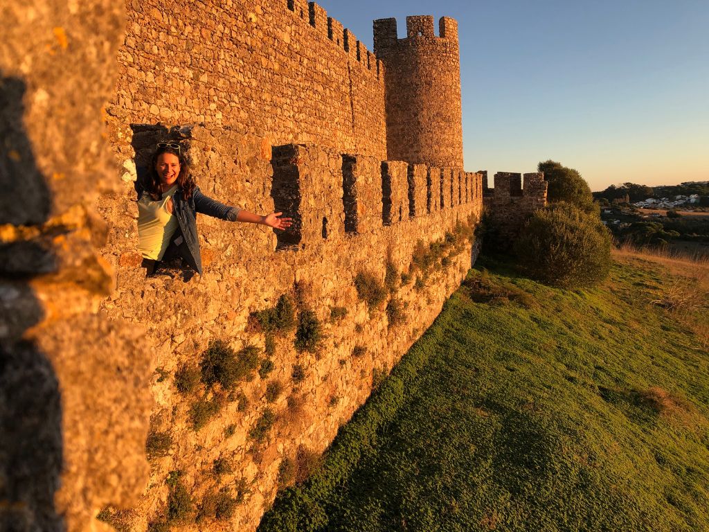 Nicola sits in the window of a castle in Santiago, a hidden gem in Portugal